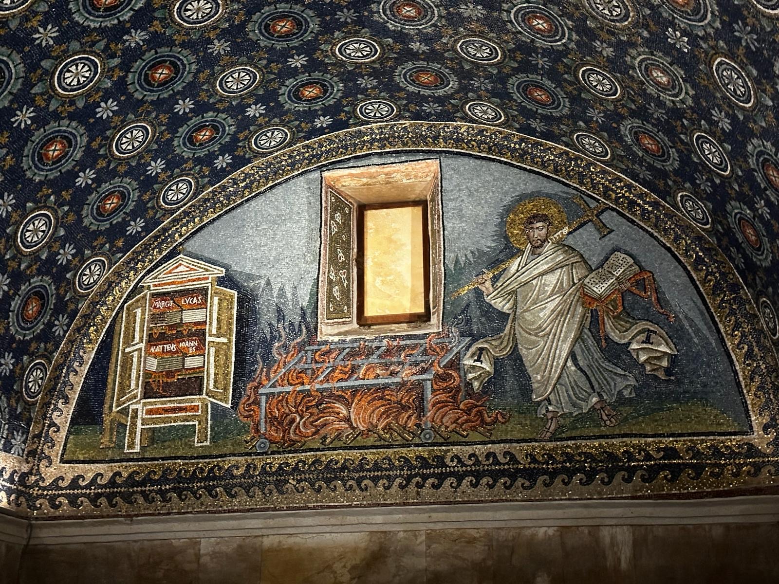 St. Lawrence and his gridiron, a mosaic in the Mausoleum of Galla Placidia in Ravenna, Italy. Photo by Karen Fletcher Smith, used with permission. https://www.turismo.ra.it/en/culture-and-history/unesco-world-heritage/mausoleum-of-galla-placidia/ 