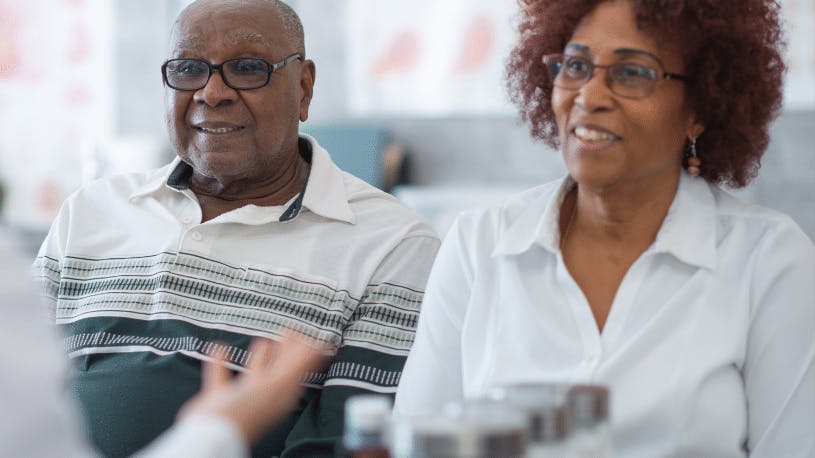 African American couple who wear glasses talk with their ophthalmologist about glaucoma risks and exams