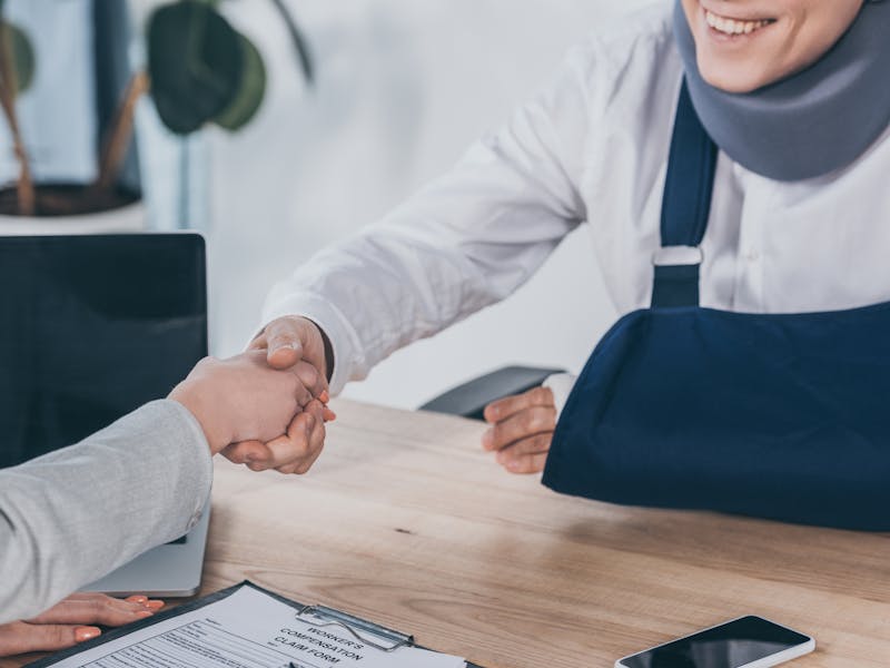 injured victim shaking hands with their lawyer 