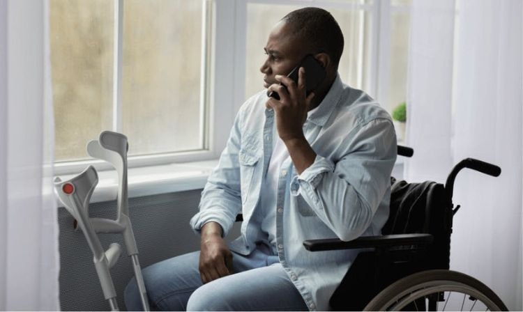 man in wheelchair making a call on his cell phone