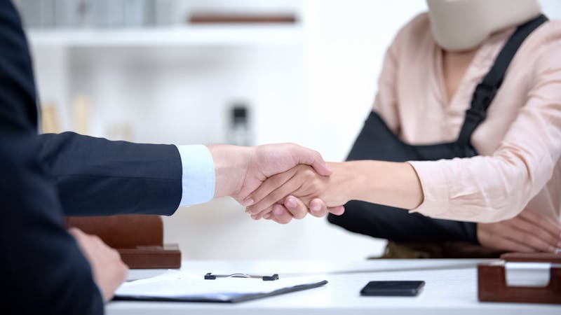 injury victim shaking hands with their lawyer