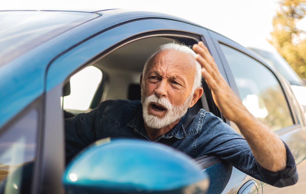 man driving his car yelling out the window