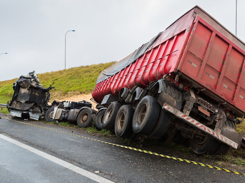 semi truck overturned on the side of the road