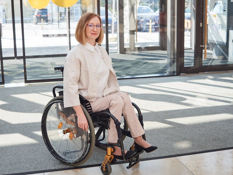 Woman in wheelchair in an office building lobby