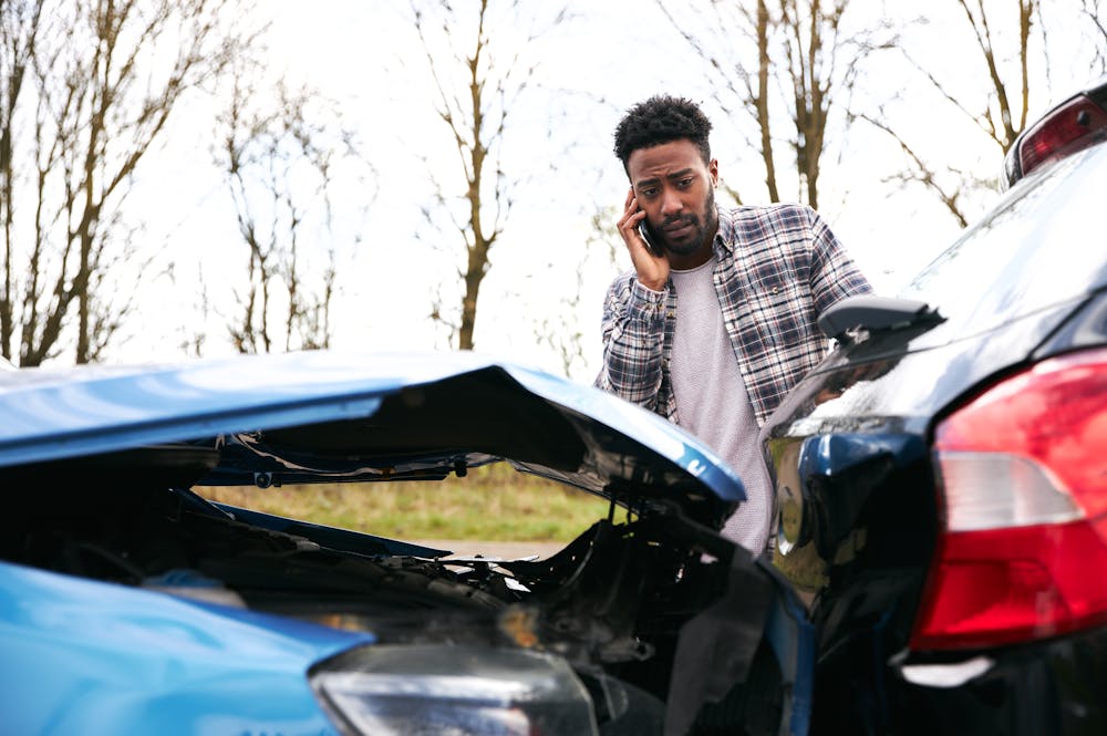 Man calling emergency services after a car accident